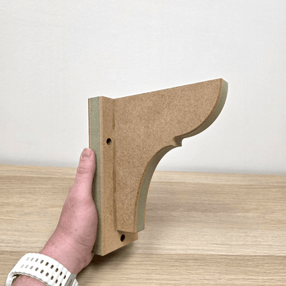 Shaker Gallows Bracket held in hand, showcasing its elegant design and precision craftsmanship.
