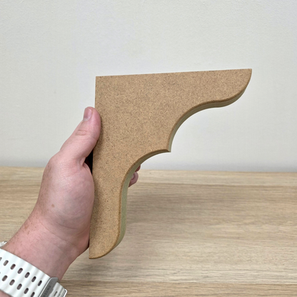 Hand holding a Traditional Shaker Shelf Bracket made of moisture-resistant MDF.